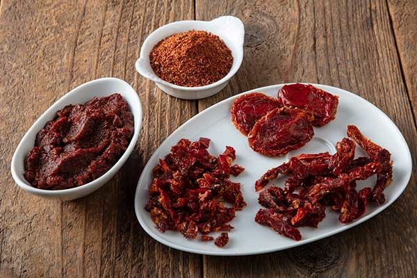 different cuts of dried tomato, including paste and powder